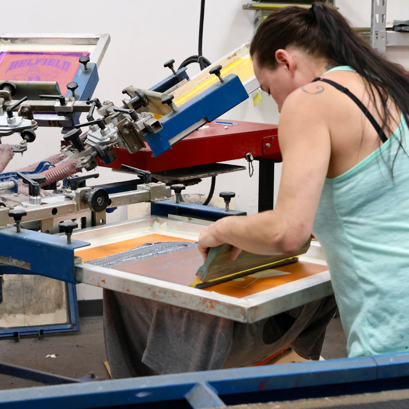 Advanced Sportswear employee screen printing in the shop